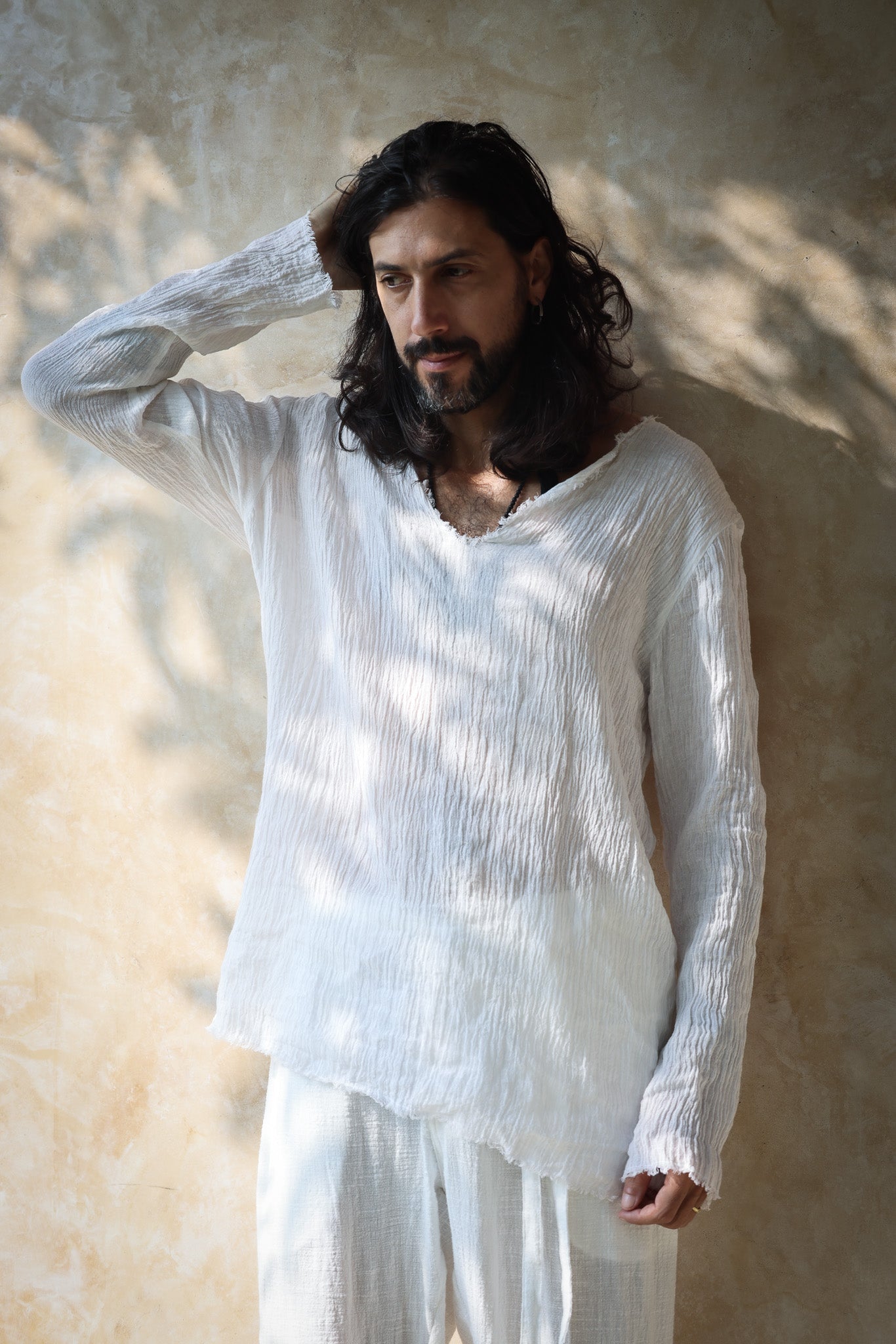 A model wearing the Kian Linen Shirt and matching drawstring pants in a crisp white tone, embodying effortless bohemian elegance. This lightweight, breathable outfit is made from natural fabrics, perfect for slow fashion enthusiasts. From Bird of Paradise, Bali boho clothings
