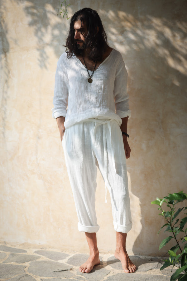 A model wearing the Kian Linen Shirt and matching drawstring pants in a crisp white tone, embodying effortless bohemian elegance. This lightweight, breathable outfit is made from natural fabrics, perfect for slow fashion enthusiasts. From Bird of Paradise, Bali boho clothing