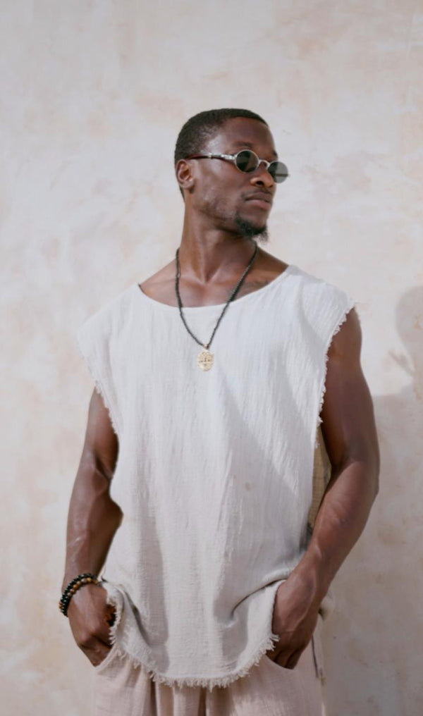 Man wearing the Aiden Shirt from Bird of Paradise, a raw-edged sleeveless top crafted from lightweight natural cotton. This bohemian-inspired, slow fashion piece is designed for effortless style and comfort, perfect for Bali boho clothing lovers.